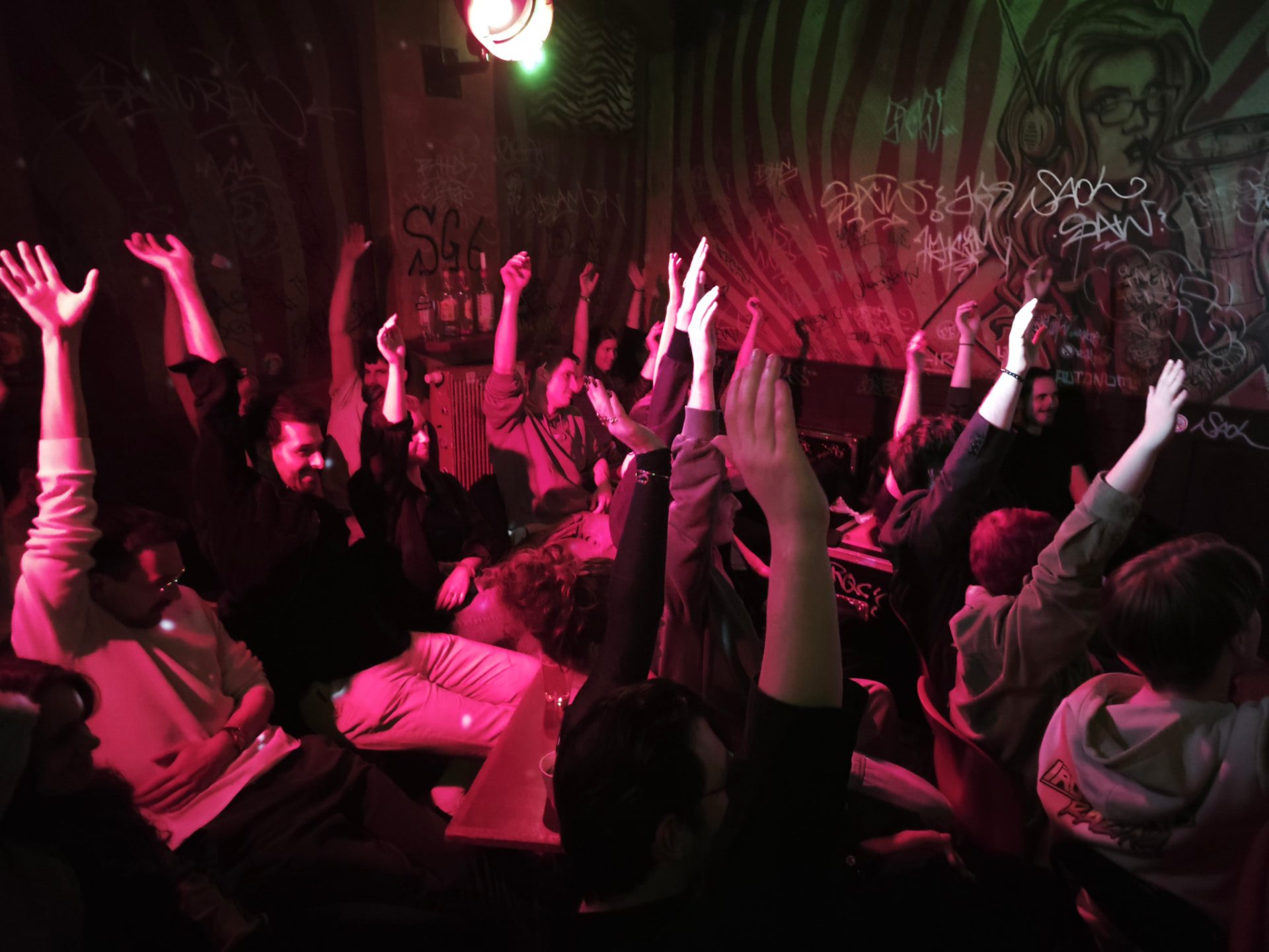 Begeistertes Publikum mit erhobenen Händen bei einem Open Mic
